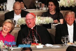 Cardinal Timothy Dolan seated between Hillary Clinton and Donald Trump.